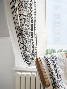 Detail of bohemian cotton linen curtain with black geometric tribal patterns and texture