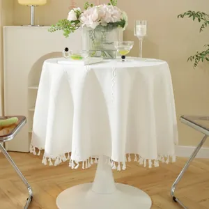 White round tablecloth with geometric jacquard pattern and tassel trim for dining tables