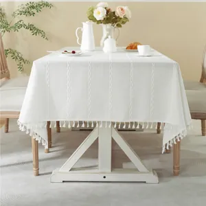 Close-up of white jacquard tablecloth with vertical stripes and elegant fringe details