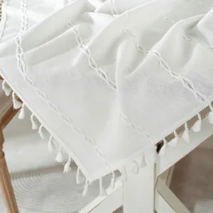 White minimalist table runner with woven braid patterns and delicate tassel trim