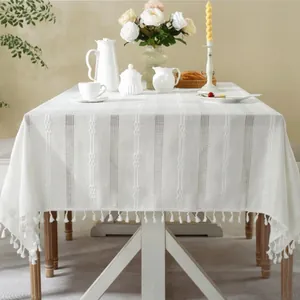 Close-up of white jacquard tablecloth featuring hollow stripes and decorative fringe details