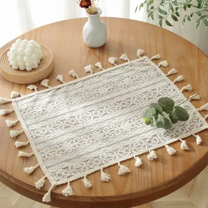 Gros plan détaillé du set de table en dentelle ivoire avec motifs floraux et franges