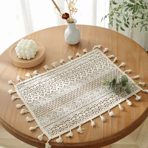 Set de table rectangulaire en dentelle beige avec franges sur une table en bois rustique