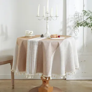 Detailed view of round tablecloth with cream fringes and central jacquard stripe pattern