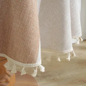 Detailed view of caramel beige woven tablecloth with fringe trim and texture