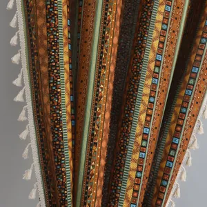 Detail of Bohemian cotton linen curtain with bronze stripes and off-white fringe tassels