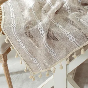 Bohemian jacquard tablecloth with white stripes and tassels on light brown linen fabric