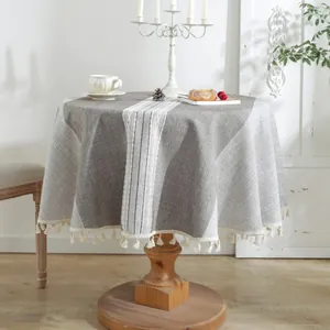 Detailed texture of cotton linen round tablecloth with grey stripes and white tassels