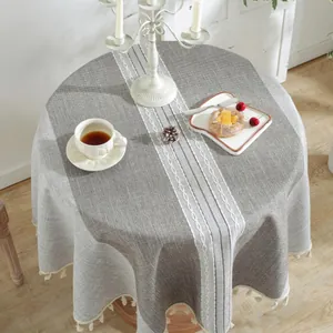 Detail of grey Nordic round tablecloth with white diamond embroidery and beige tassel trim