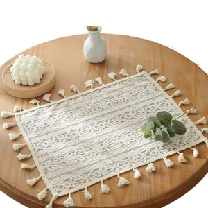Set de table rectangulaire en dentelle crème avec franges sur une table en bois