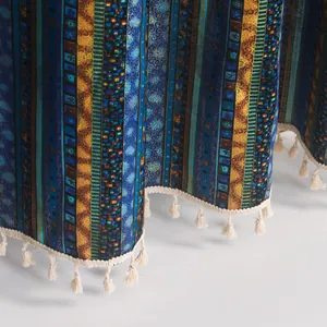 Detail of blue and gold striped cotton linen fabric with tassels for bohemian curtains