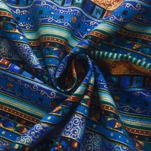 Detail of bohemian curtain fabric with gold metallic patterns and navy blue fringes