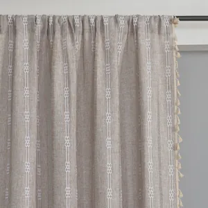 Close-up of striped polyester curtain with white woven patterns and beige tassels