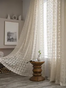 Dettaglio di tenda in pizzo all'uncinetto con motivi geometrici in stile boho
