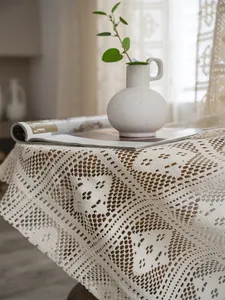 Dettaglio della tovaglia in pizzo all'uncinetto con motivi floreali e geometrici retrò