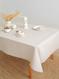 Detail van beige gestreept tafelkleed met linnen textuur in een Scandinavische eetkamer