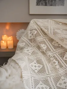 Dettaglio macro della tenda in cotone a maglia retrò con motivi geometrici all'uncinetto
