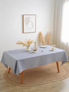 Detail van een blauw en wit gestreept tafelkleed met franjes op een eettafel