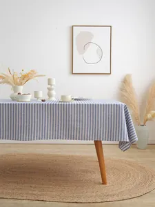 Detail van blauw-wit gestreept linnen tafelkleed op houten tafel met natuurlijke val