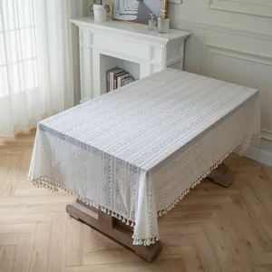Detail of beige lace tablecloth featuring hollow embroidery and elegant fringe tassels