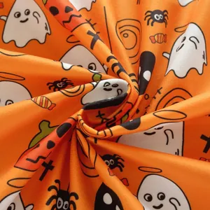 Detailed close-up of Halloween orange tablecloth with ghost and pumpkin printed patterns
