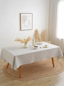 Detail van grijs gestreept Scandinavisch tafelkleed op een rechthoekige houten tafel