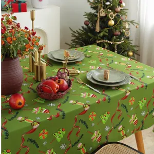 Dettaglio della tovaglia natalizia verde con stampe festive come alberi e bastoncini