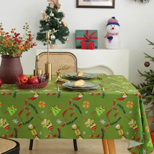 Dettaglio tovaglia natalizia verde con motivi di renne e alberi festivi colorati