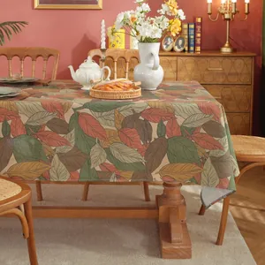 Detail showing high-quality cotton linen fabric with autumn maple leaf prints on a table
