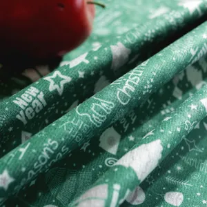 Dettaglio della tovaglia natalizia verde con stampe di renne e auguri di Natale