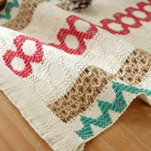 Detailaufnahme des rustikalen nordischen Tischsets mit roten Mustern und Fransen