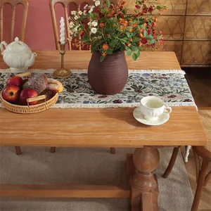 Dettaglio ravvicinato del runner da tavolo jacquard ad alta precisione con nappe e fiori