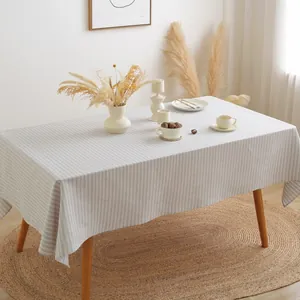 Japans gestreept linnen tafelkleed in grijs en wit op een moderne houten eettafel