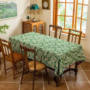 Detail of dark green floral tablecloth with dense pink and white jacquard patterns