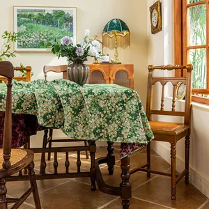 Detail of forest green jacquard tablecloth showing delicate floral patterns and texture