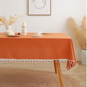 Noords minimalistisch pompoen oranje katoenen tafelkleed met elegante witte kwastjes decor