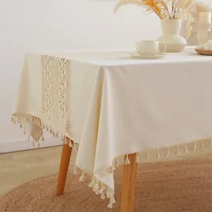Boho linen tablecloth with lace splicing and tassel edges on a wooden table