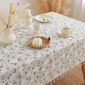 Linen cotton tablecloth with white dandelion floral print and tassels in home setting
