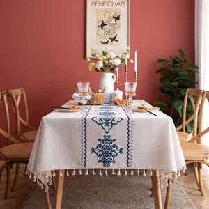 Detailed view of jacquard leaf embroidery and white tassels on a rectangular tablecloth