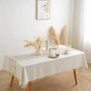 Detail of minimalist cotton linen tablecloth with crochet hollow stitching and delicate tassels