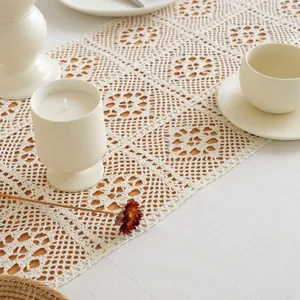 Detail of cream crochet lace table runner with vintage floral patchwork patterns