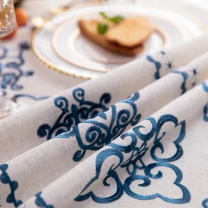 Detail of blue floral embroidery on rustic linen tablecloth with premium texture