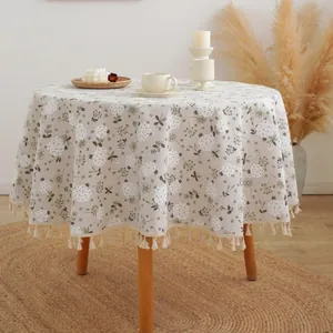 Round linen tablecloth with white floral pattern and elegant tassel fringe trim