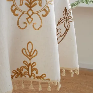Primer plano del mantel jacquard bordado con flecos de borlas beige hechos a mano