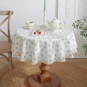 Cream linen round tablecloth with embroidered daisies and elegant tassel fringe detail
