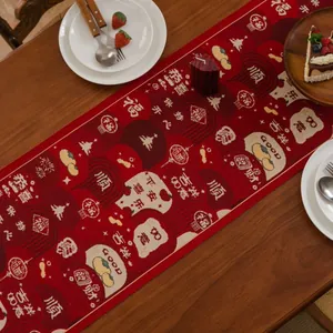 Detail of red jacquard table runner featuring traditional Chinese lanterns and patterns