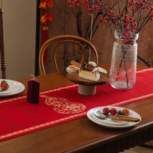 Detailed embroidery of gold gourd pattern on festive red Chinese table runner