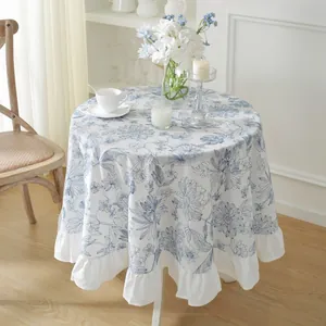 Floral blue cotton tablecloth with ruffles and waterproof coating on round dining table