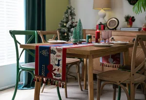 Detail of Christmas table runner with reindeer patterns and festive tassel decoration