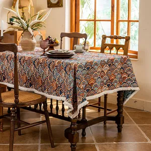 Detail of retro jacquard tablecloth with orange scallop pattern and cream woven tassels